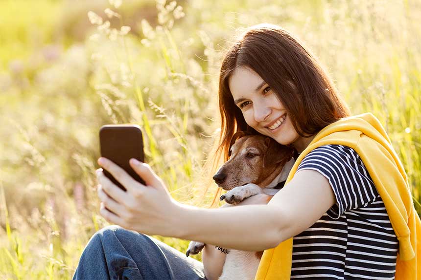 Belle fille avec chien prends un selfie